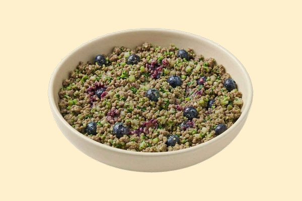 A bowl of cooked ground lamb with quinoa, blueberries, broccoli and parsley